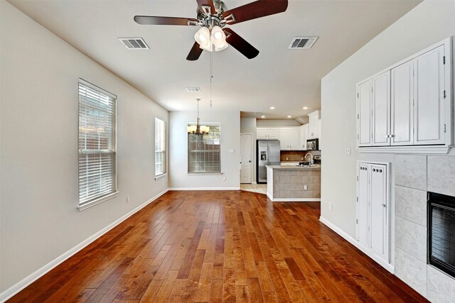 11000 Anderson Mill Rd Unit 52, Austin, TX 78750 - unfurnished living room featuring hardwood / wood-style flooring, baseboards, a ceiling fan, a chandelier, and recessed lighting