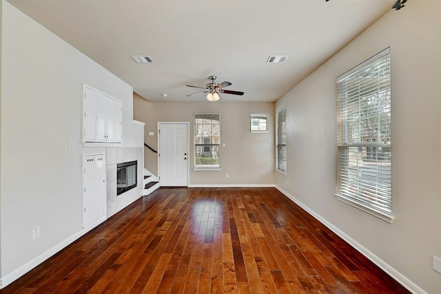 11000 Anderson Mill Rd Unit 52, Austin, TX 78750 - unfurnished living room with dark wood finished floors, baseboards, ceiling fan, and a tile fireplace