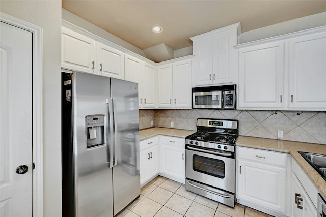 11000 Anderson Mill Rd Unit 52, Austin, TX 78750 - kitchen featuring appliances with stainless steel finishes, light tile patterned flooring, white cabinets, decorative backsplash, and recessed lighting