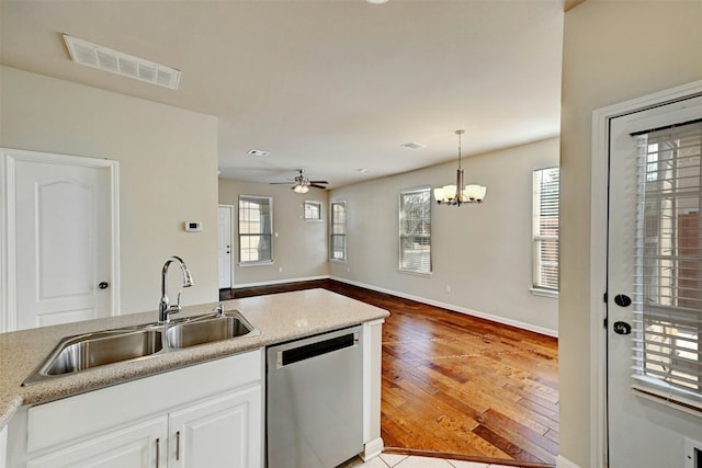 kitchen featuring a sink, visible vents, white cabinetry, stainless steel dishwasher, and pendant lighting