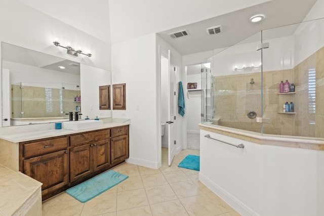 full bath with tile patterned floors, visible vents, a tile shower, and vanity