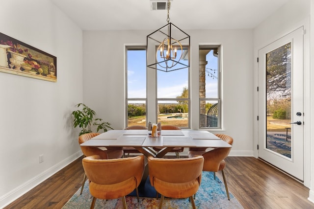 dining space with a notable chandelier, baseboards, visible vents, and wood finished floors