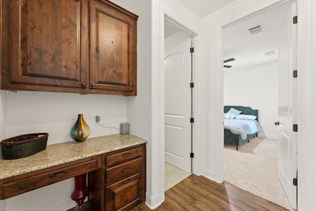 interior space featuring baseboards, visible vents, dark carpet, and dark wood-style flooring