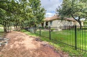 view of property exterior featuring fence and a lawn