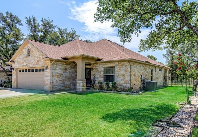 view of front of property with driveway, a shingled roof, an attached garage, central air condition unit, and a front lawn