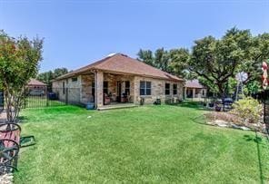 back of house featuring fence and a lawn