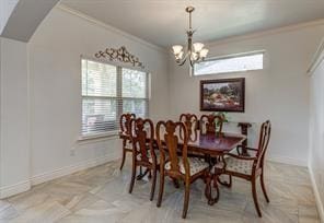 dining space with an inviting chandelier, baseboards, ornamental molding, and arched walkways