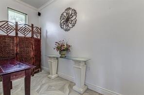 doorway to outside featuring crown molding and baseboards