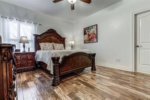 bedroom with a ceiling fan, baseboards, and wood finished floors