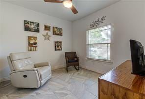 interior space with a ceiling fan and baseboards