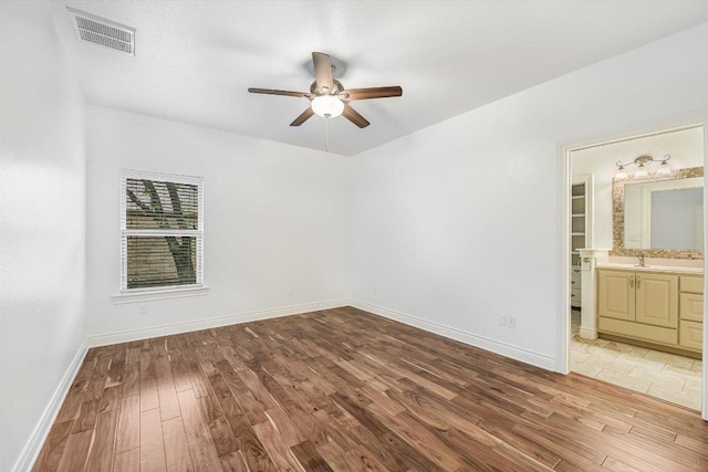 604 Caprock Canyon Trl, Georgetown, TX 78633 - unfurnished bedroom with baseboards, ensuite bath, light wood-style flooring, and visible vents