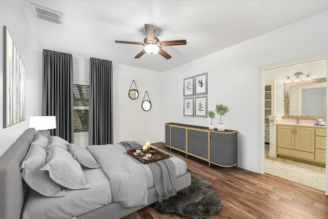 604 Caprock Canyon Trl, Georgetown, TX 78633 - bedroom featuring a ceiling fan, light wood-style floors, visible vents, baseboards, and ensuite bath