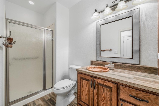 604 Caprock Canyon Trl, Georgetown, TX 78633 - bathroom featuring a stall shower, vanity, toilet, and wood finished floors