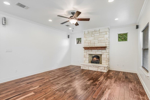 604 Caprock Canyon Trl, Georgetown, TX 78633 - unfurnished living room with wood finished floors, visible vents, a fireplace, ceiling fan, and crown molding