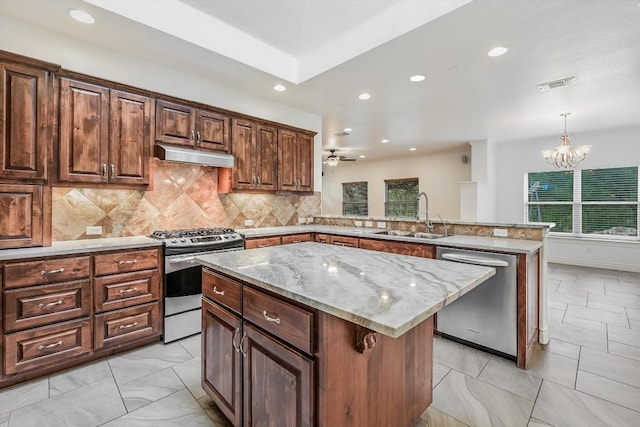 604 Caprock Canyon Trl, Georgetown, TX 78633 - kitchen featuring a sink, under cabinet range hood, plenty of natural light, and appliances with stainless steel finishes