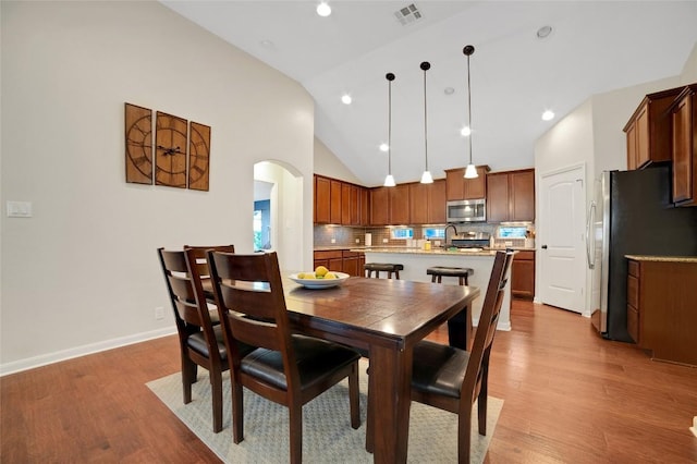 2405 Billy Pat Rd, Leander, TX 78641 - dining space with lofted ceiling, wood finished floors, arched walkways, and recessed lighting