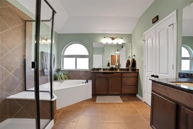2405 Billy Pat Rd, Leander, TX 78641 - full bathroom with plenty of natural light, two vanities, a shower stall, lofted ceiling, and a bath