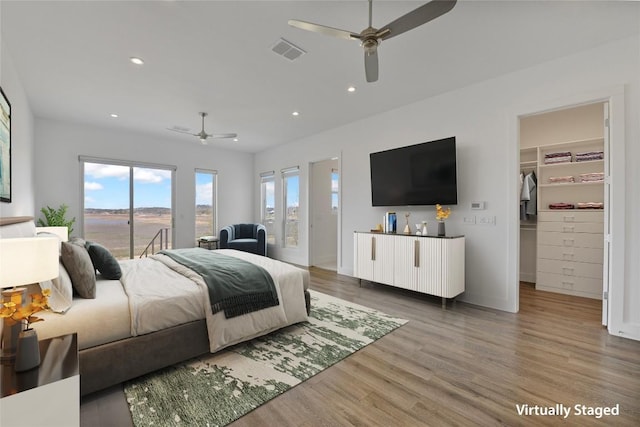 bedroom featuring recessed lighting, wood finished floors, visible vents, access to exterior, and a spacious closet