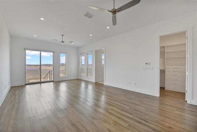 unfurnished living room featuring light wood-style floors, baseboards, and visible vents