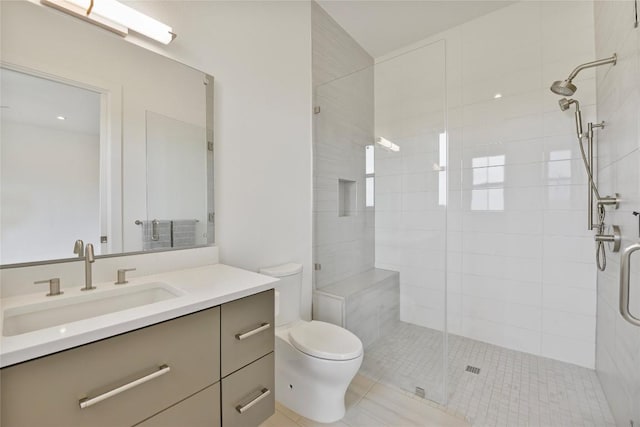 bathroom featuring toilet, a shower stall, and vanity