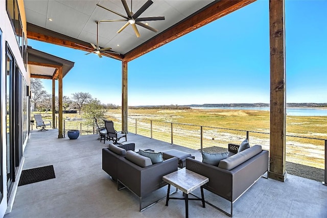 view of patio with a ceiling fan, a water view, and an outdoor living space