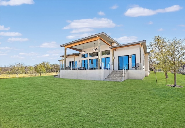 rear view of property with a lawn and a ceiling fan