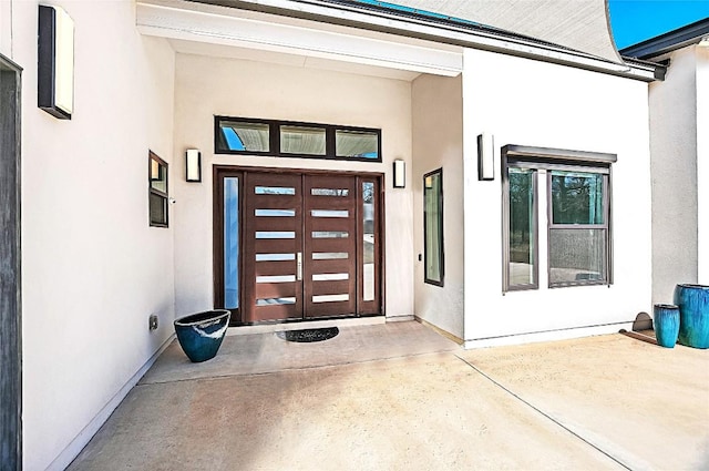 view of exterior entry with stucco siding