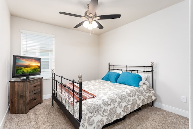 bedroom with a ceiling fan, light carpet, and baseboards