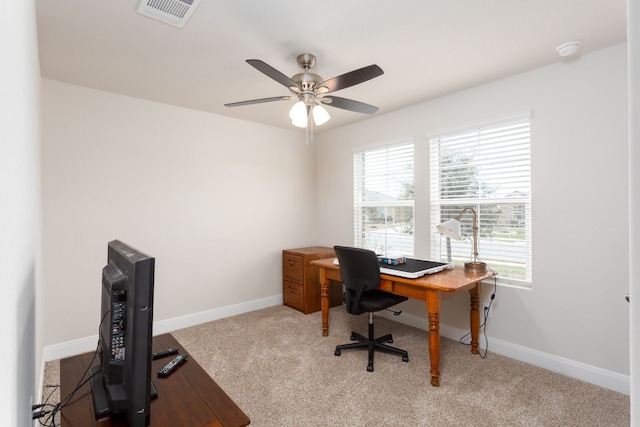 office area with a ceiling fan, light colored carpet, visible vents, and baseboards