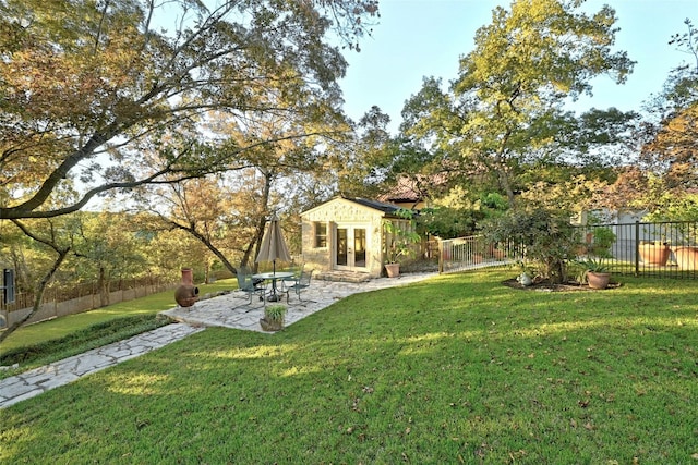 view of yard featuring a patio, an outdoor structure, and a fenced backyard