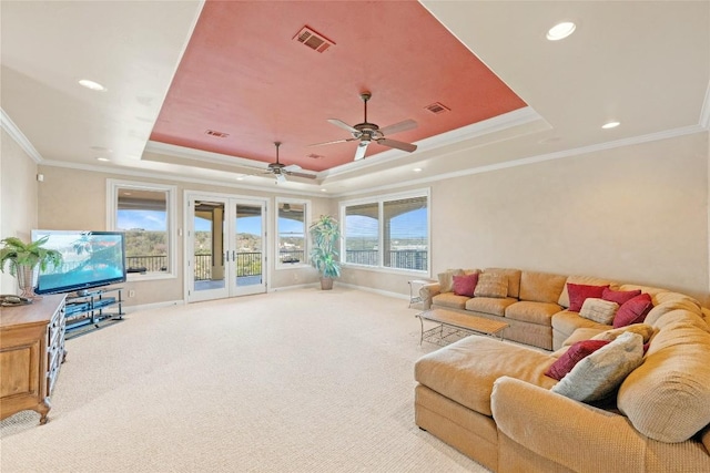 living room featuring a raised ceiling, visible vents, and french doors