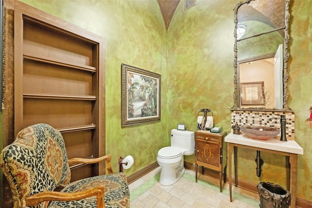 half bathroom featuring built in shelves, visible vents, a sink, and toilet