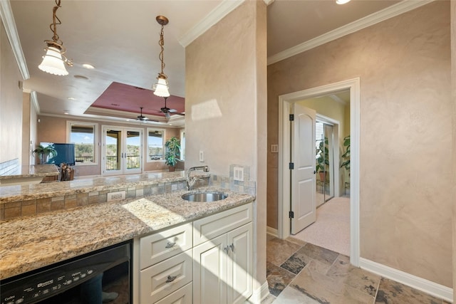 kitchen featuring beverage cooler, a sink, white cabinetry, ornamental molding, and a tray ceiling