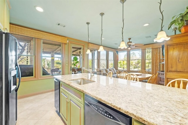 kitchen featuring visible vents, dishwasher, black fridge with ice dispenser, light stone counters, and a sink