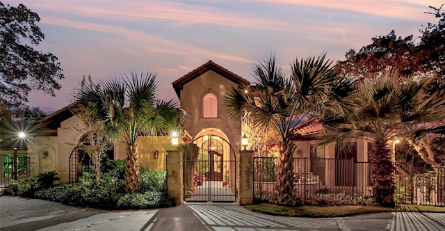 view of front of home with fence, a gate, and stucco siding