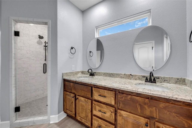 full bath with double vanity, a stall shower, and a sink