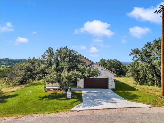 view of front of property with a garage, concrete driveway, stone siding, and a front lawn