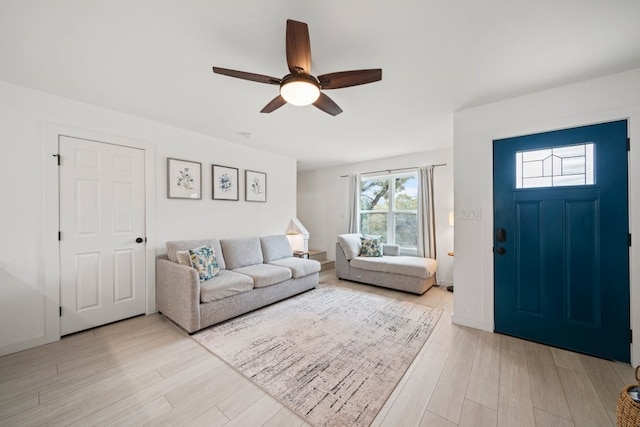 living area featuring light wood-style flooring and a ceiling fan