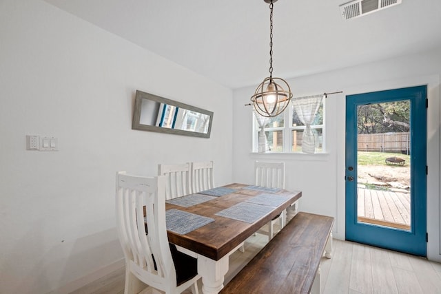 dining area featuring light wood-type flooring and visible vents