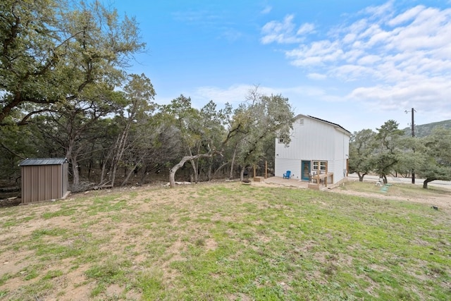 view of yard featuring a storage shed and an outbuilding