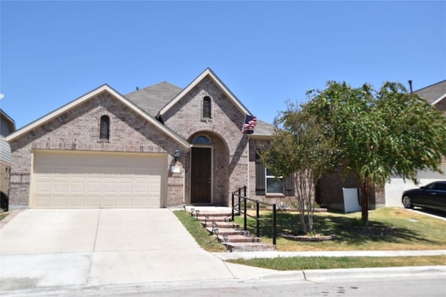 221 Joseph Dr, Buda, TX 78610 - french country inspired facade featuring brick siding, an attached garage, and concrete driveway