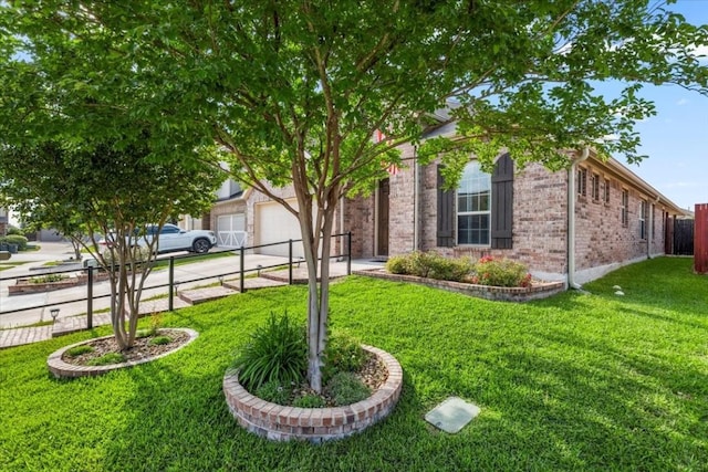 221 Joseph Dr, Buda, TX 78610 - view of front of house featuring an attached garage, driveway, a front lawn, and brick siding