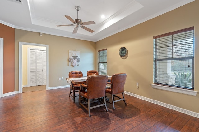 dining area with dark wood-style floors, baseboards, and a raised ceiling