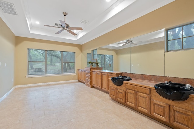 bathroom featuring crown molding, a tray ceiling, visible vents, and a sink