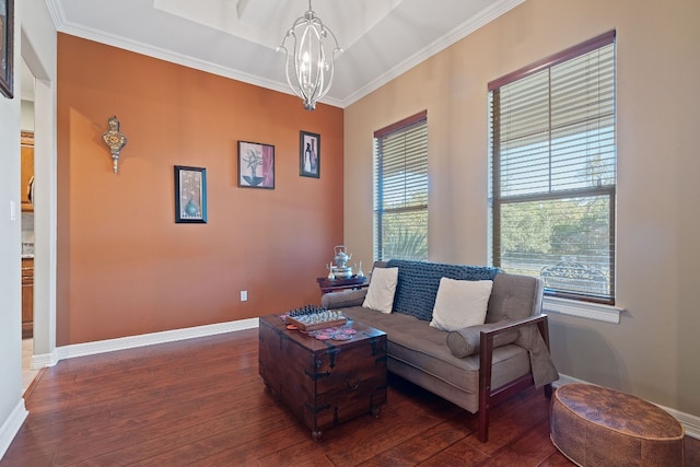 living area with dark wood-style floors, crown molding, baseboards, and an inviting chandelier