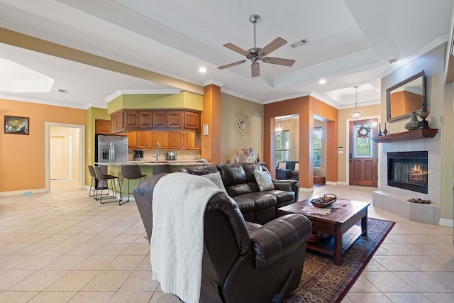 living area with ornamental molding, a raised ceiling, visible vents, and light tile patterned floors