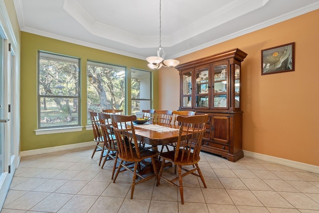 dining room with light tile patterned floors, baseboards, ornamental molding, a tray ceiling, and a notable chandelier