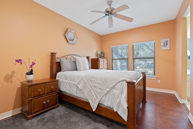 bedroom with dark wood-type flooring, ceiling fan, and baseboards