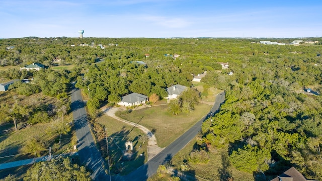 drone / aerial view featuring a wooded view