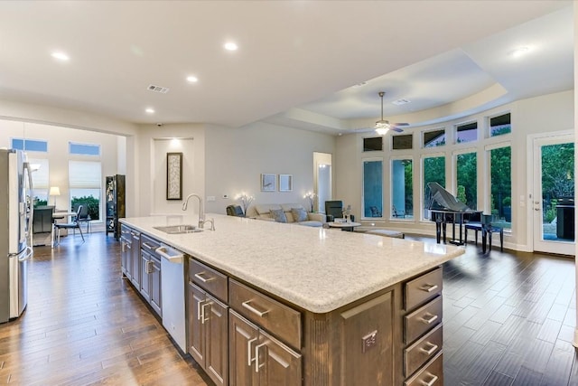 kitchen featuring stainless steel appliances, visible vents, open floor plan, a kitchen island with sink, and a sink